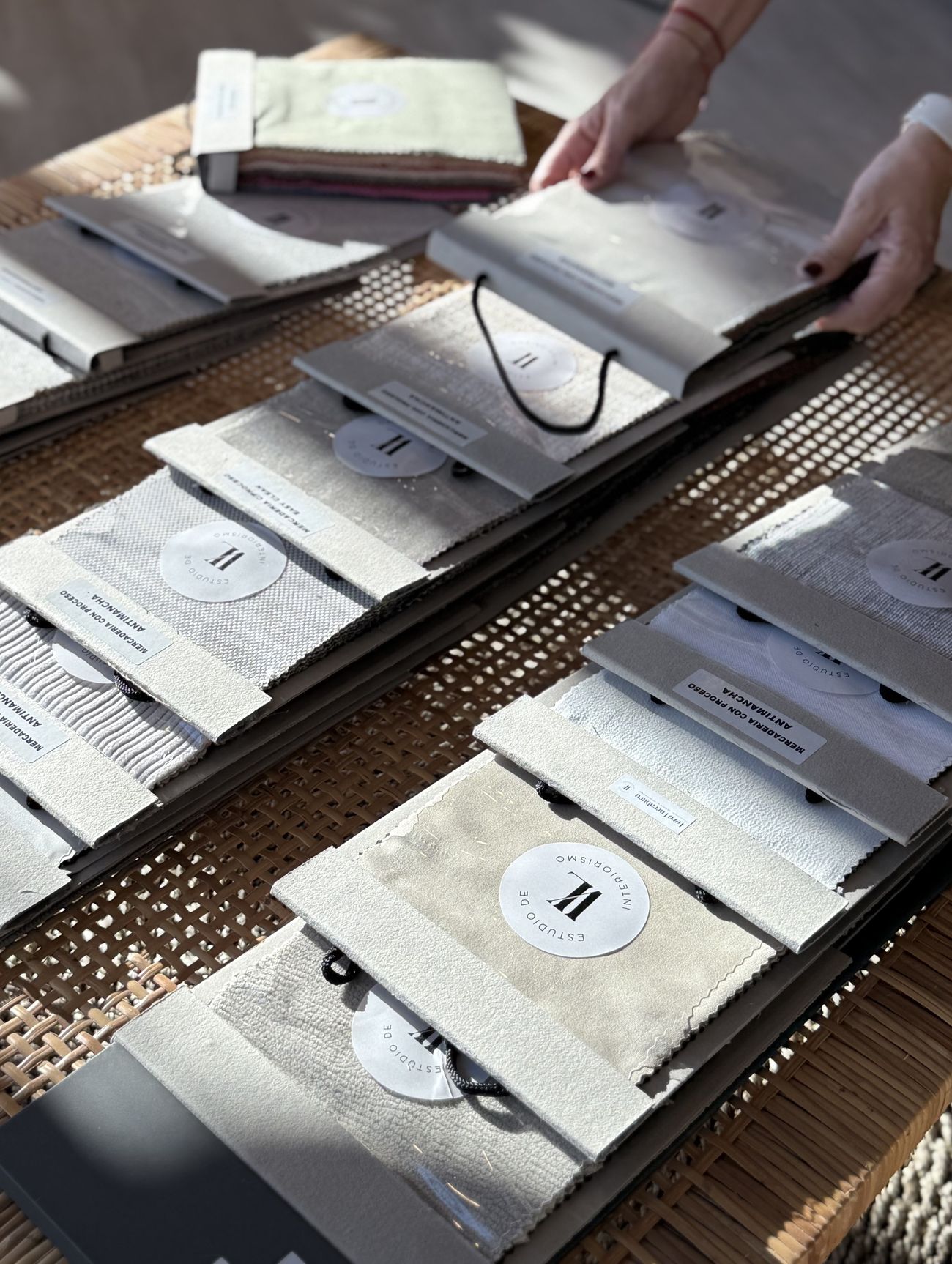 Muestrarios de géneros del estudio, organizados sobre una mesa